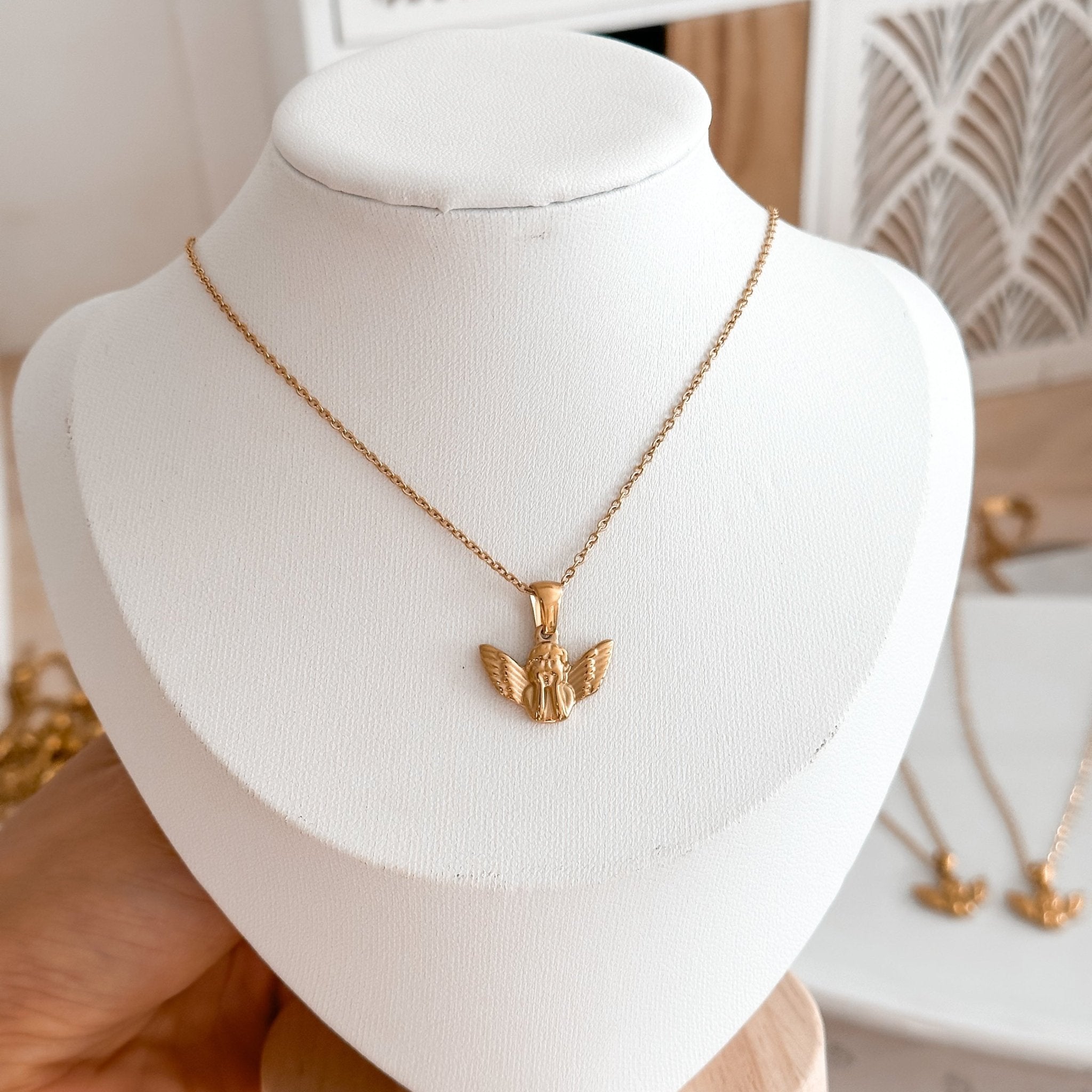 Close-up of the 18K Gold Angel Necklace, focusing on the symbolic angel charm, representing love and protection