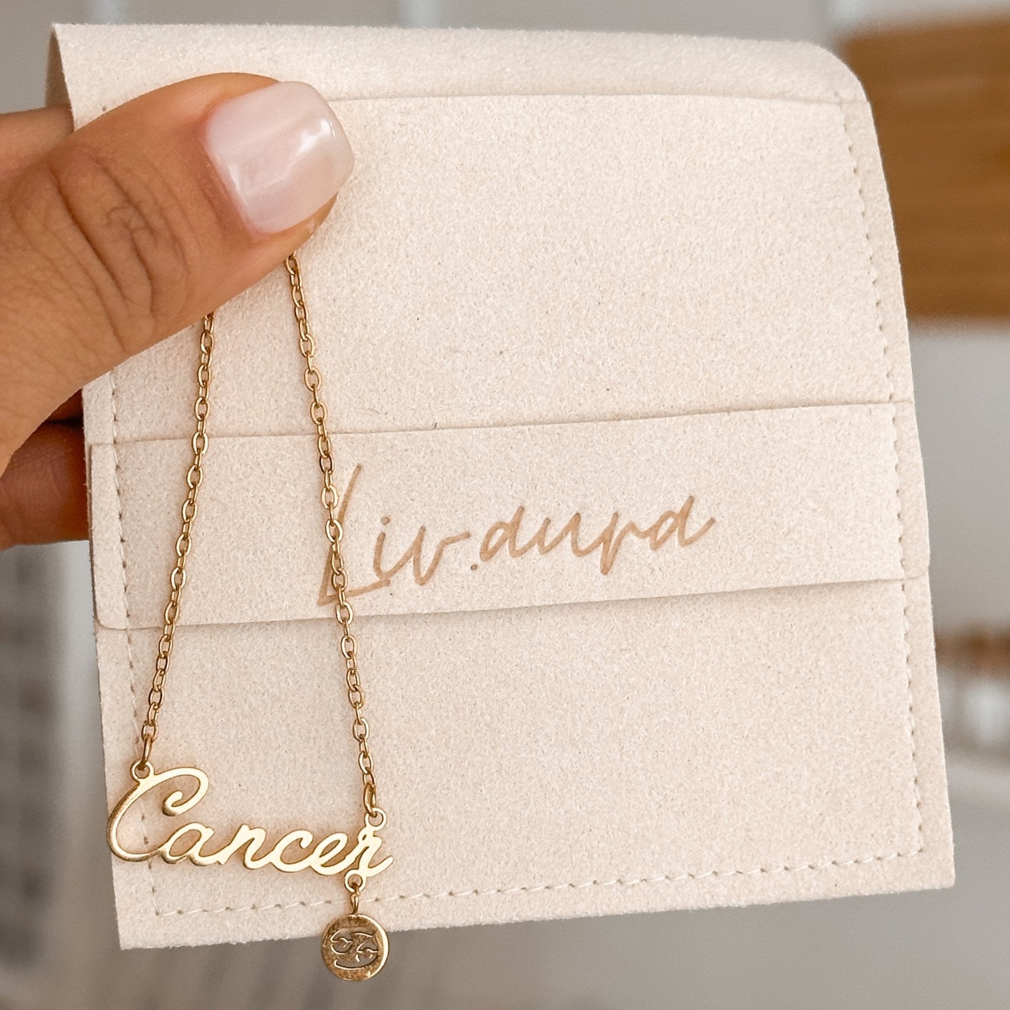 Cancer zodiac necklace featured solo on a soft neutral surface