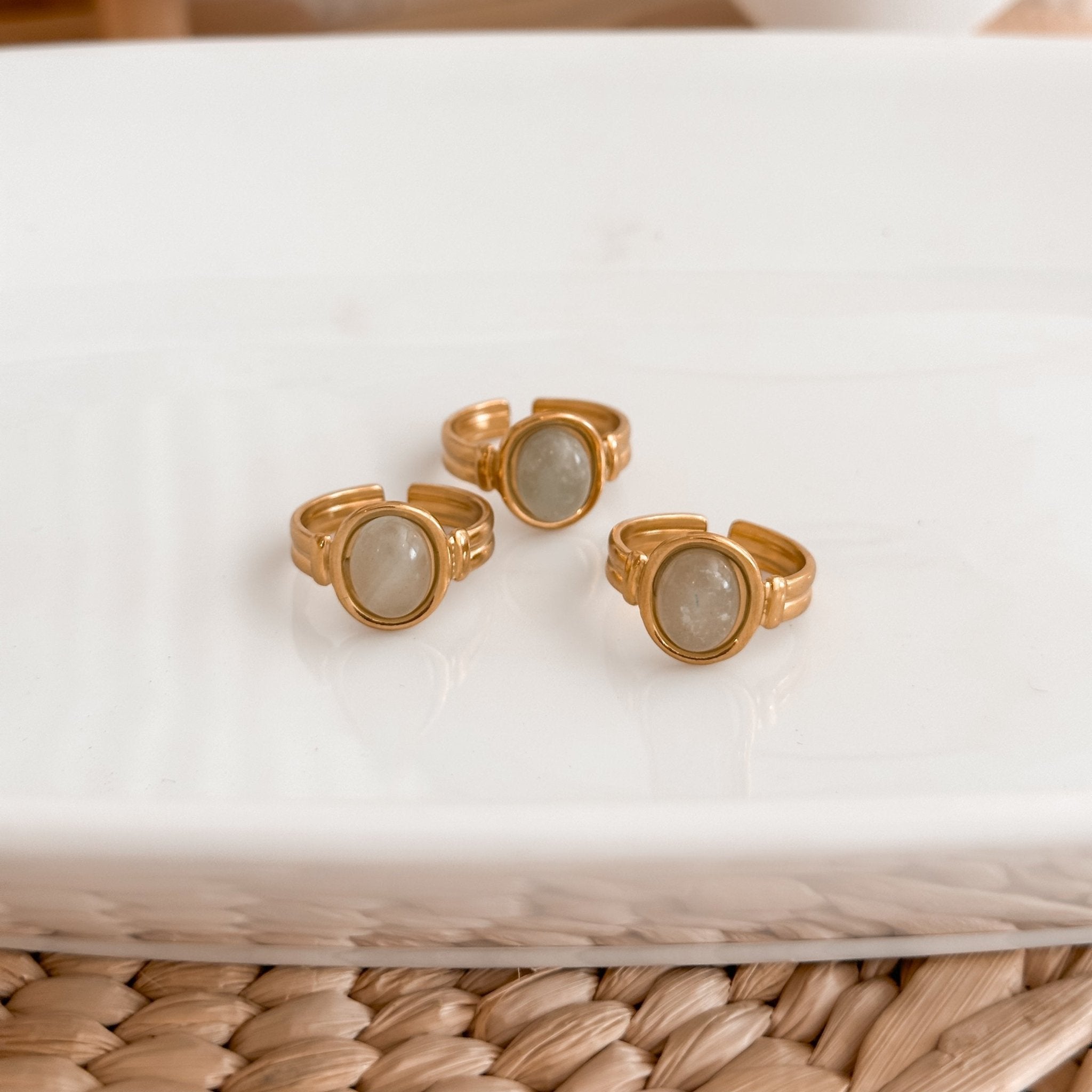 Green stone ring set on ceramic dish for minimalist styling