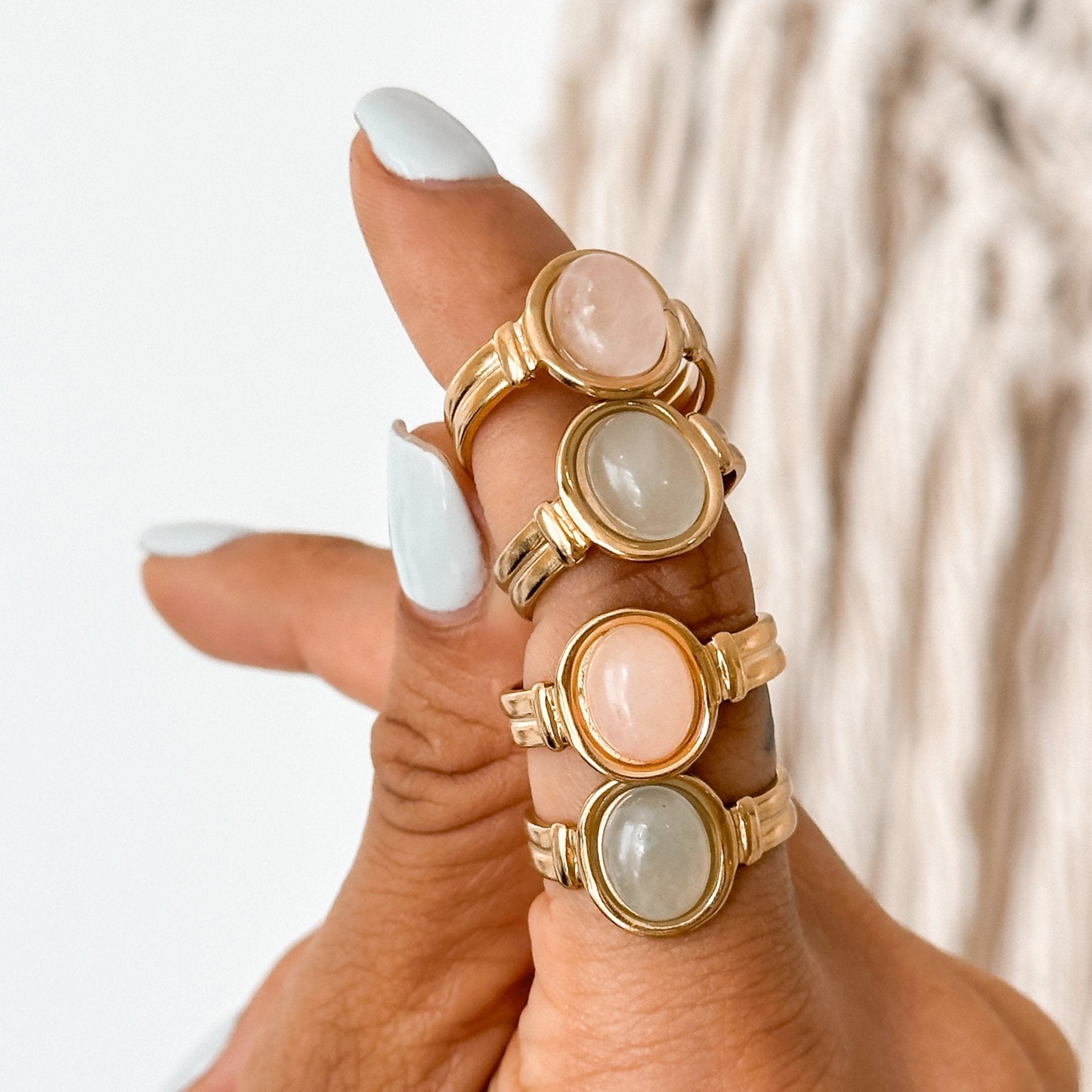 Mixed pink and green stone rings styled together on hand