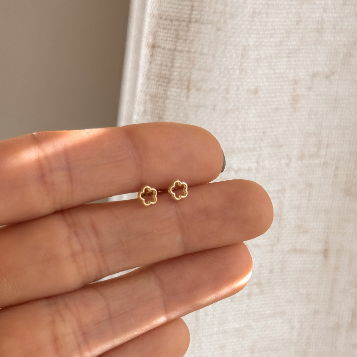10K solid gold flower stud earrings held in hand to show the size – Liv Aura