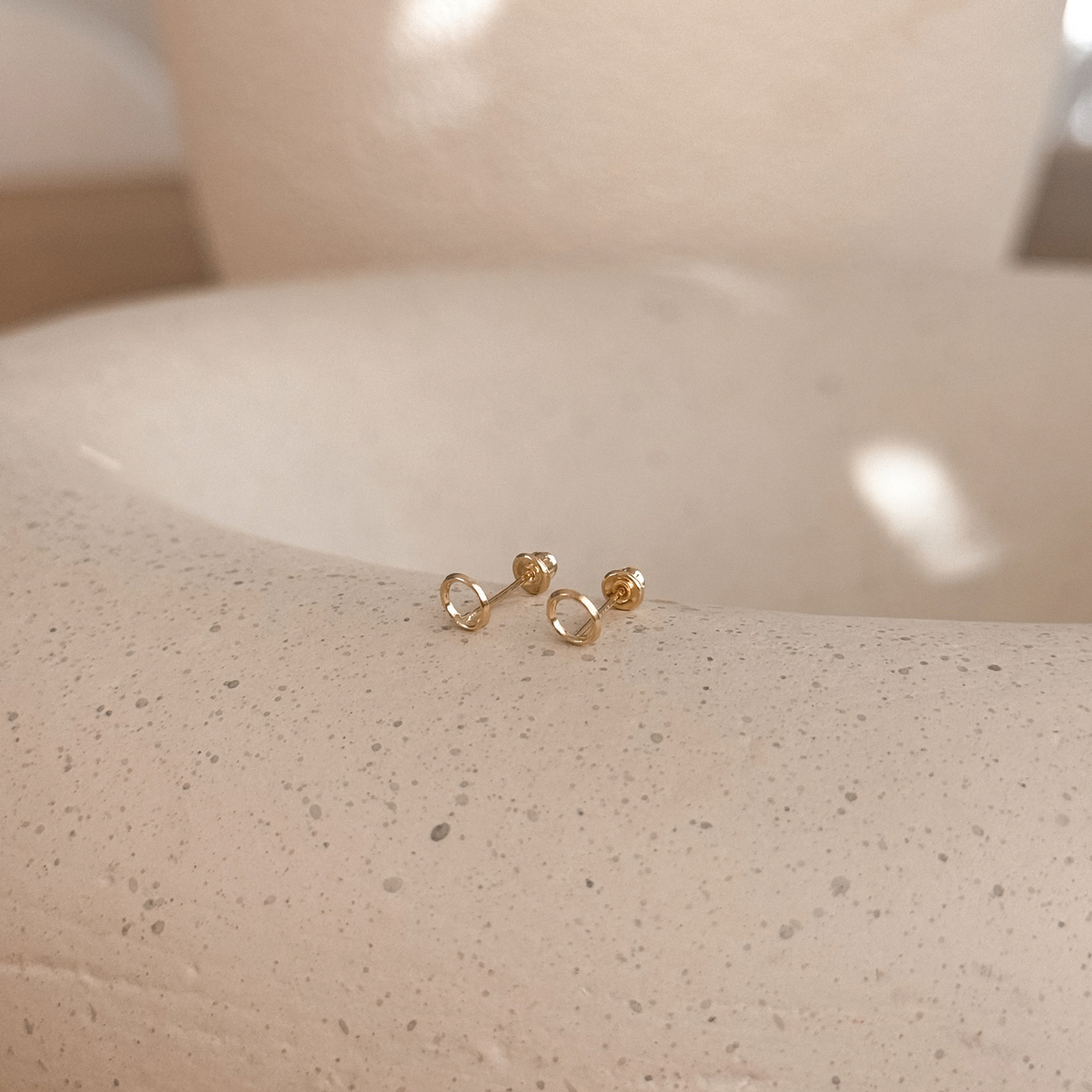 10K solid gold open circle stud earrings with screw backs on a speckled stone dish – Liv Aura