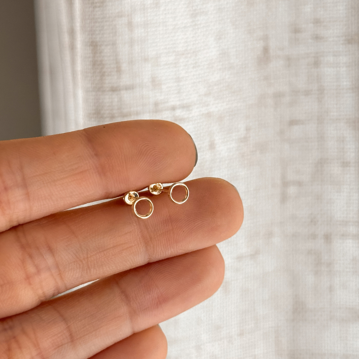 10K solid gold open circle stud earrings held in hand to show the size – Liv Aura
