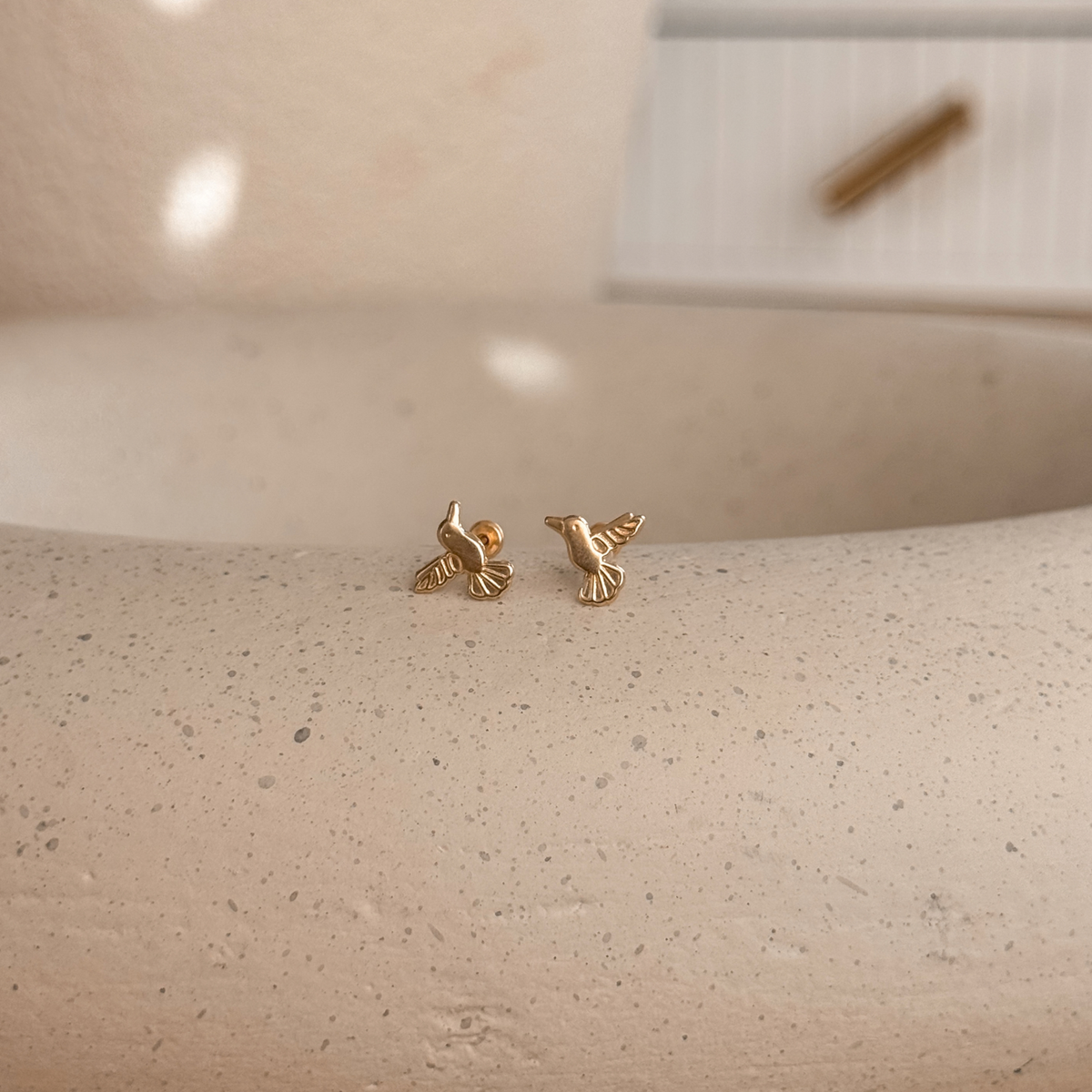 10K solid gold hummingbird stud earrings with screw backs on a speckled stone dish – Liv Aura
