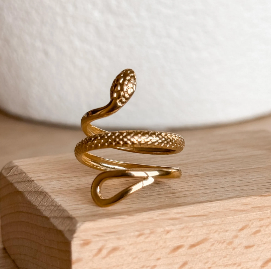 Snake Ring in gold on a wooden block – Liv Aura