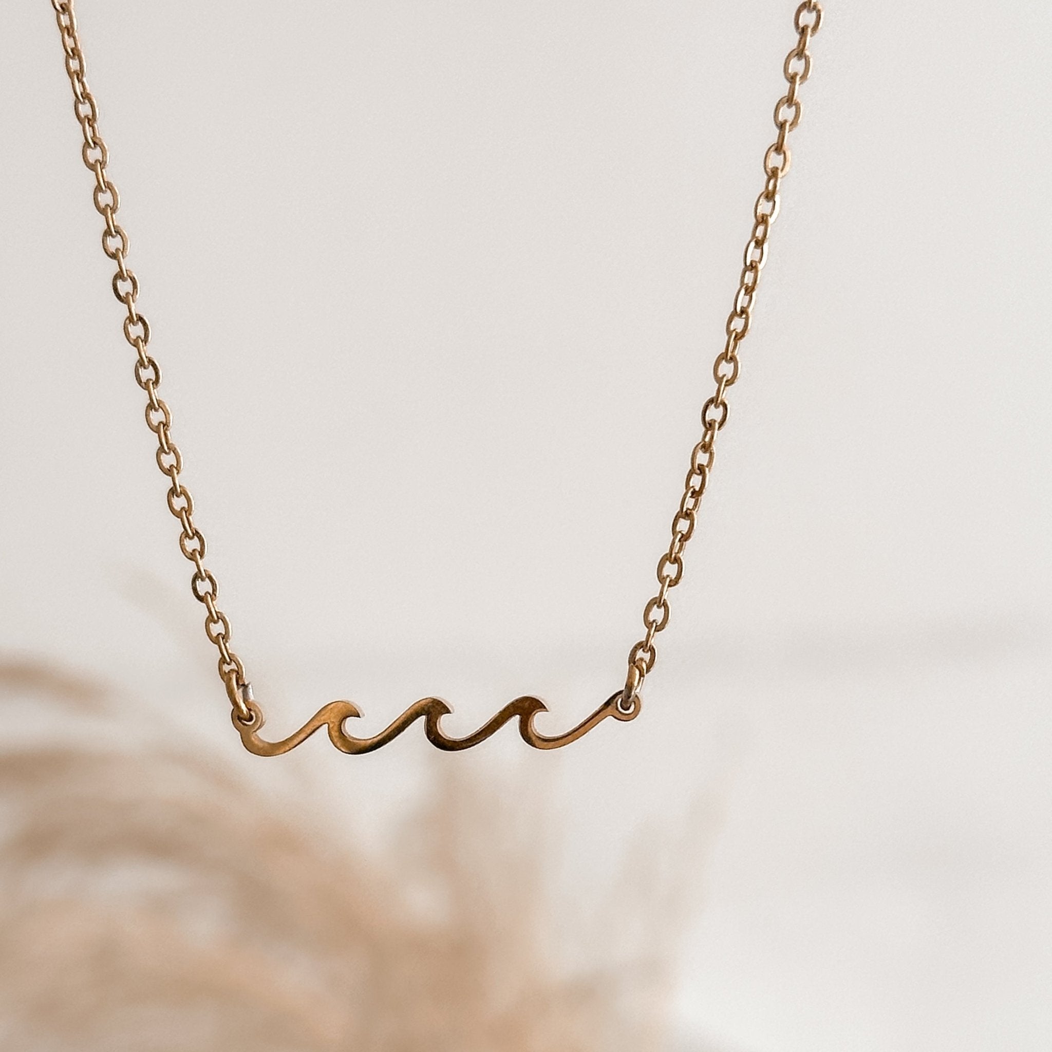 18K Gold Wave Necklace displayed on a minimalist background, perfect for surf enthusiasts