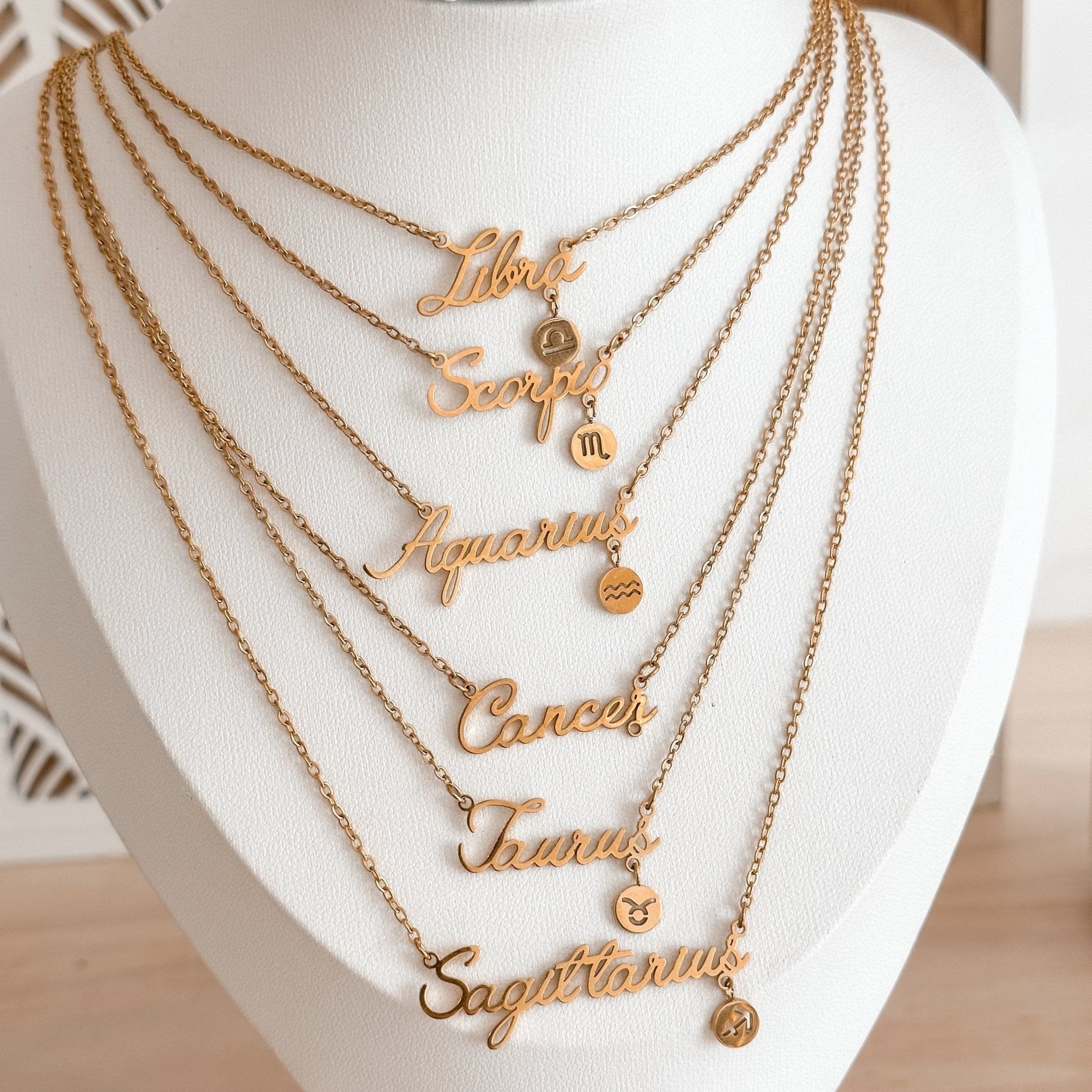 Libra, Scorpio, Aquarius, Cancer, Taurus and Sagittarius zodiac necklaces displayed together