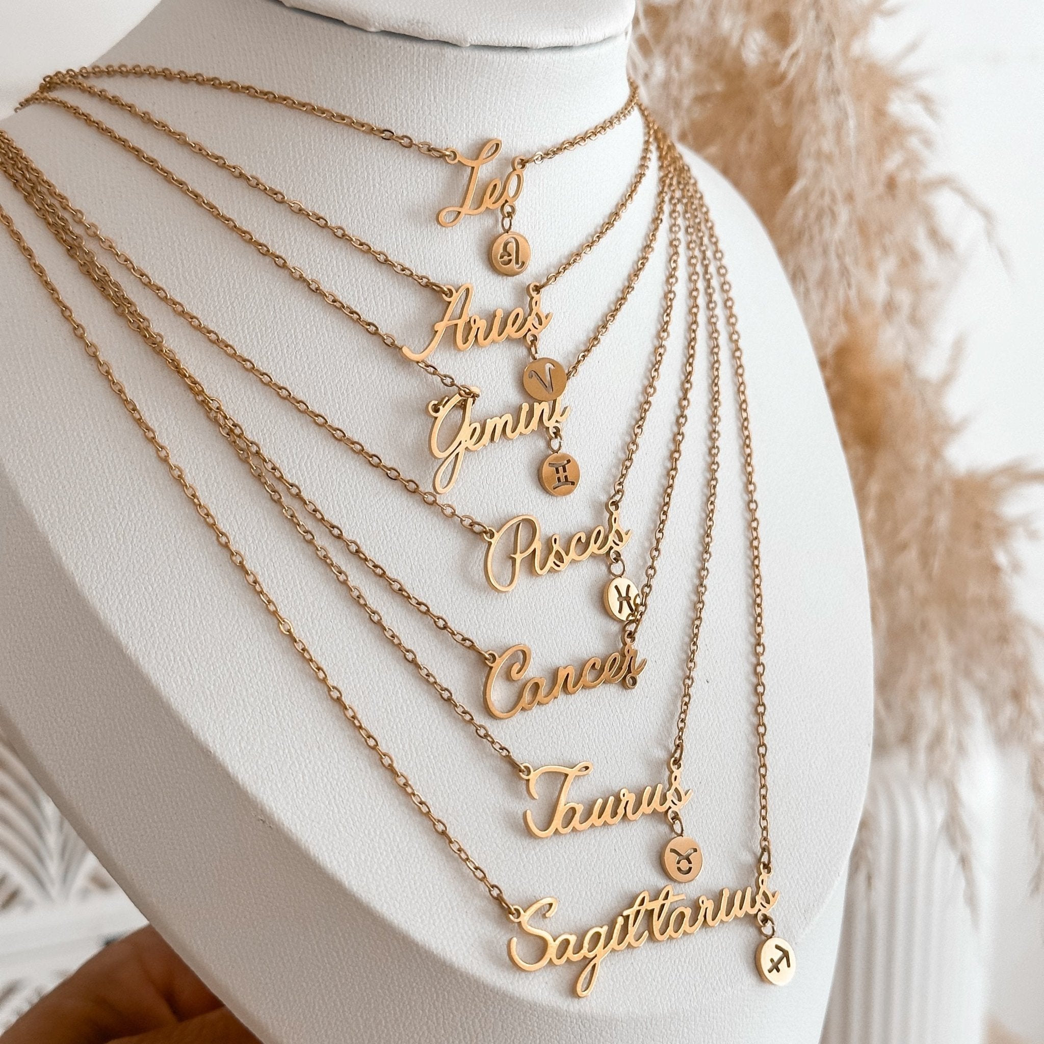 Leo, Aries, Gemini, Pisces, Cancer, Taurus and Sagittarius zodiac necklaces on a necklace display