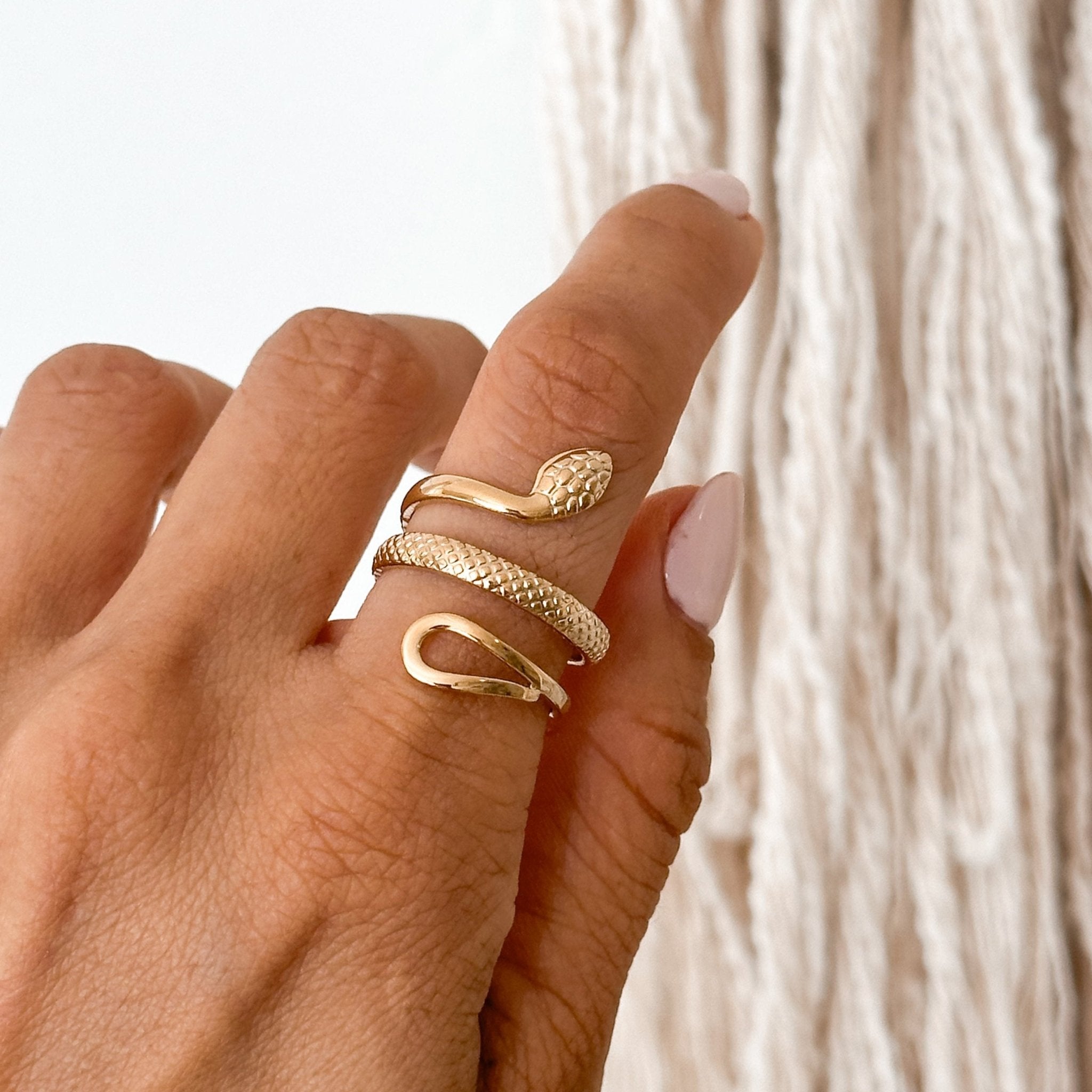 Adjustable 18K gold snake ring worn on finger, showcasing its bold and elegant design.