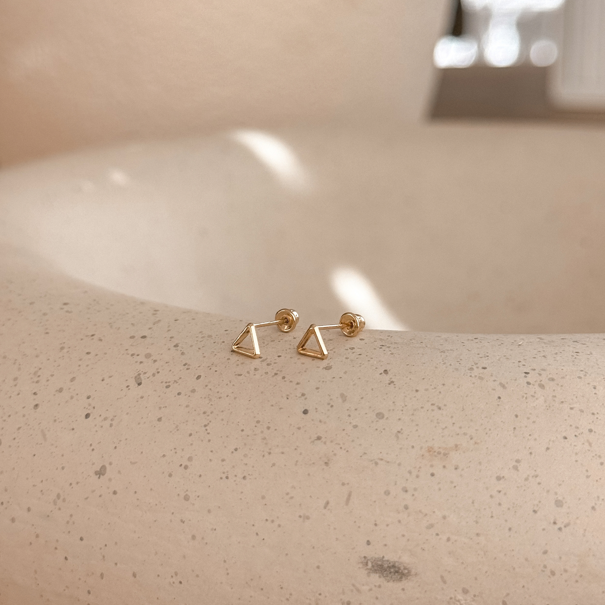10K solid gold open triangle stud earrings with screw backs on a speckled stone dish – Liv Aura