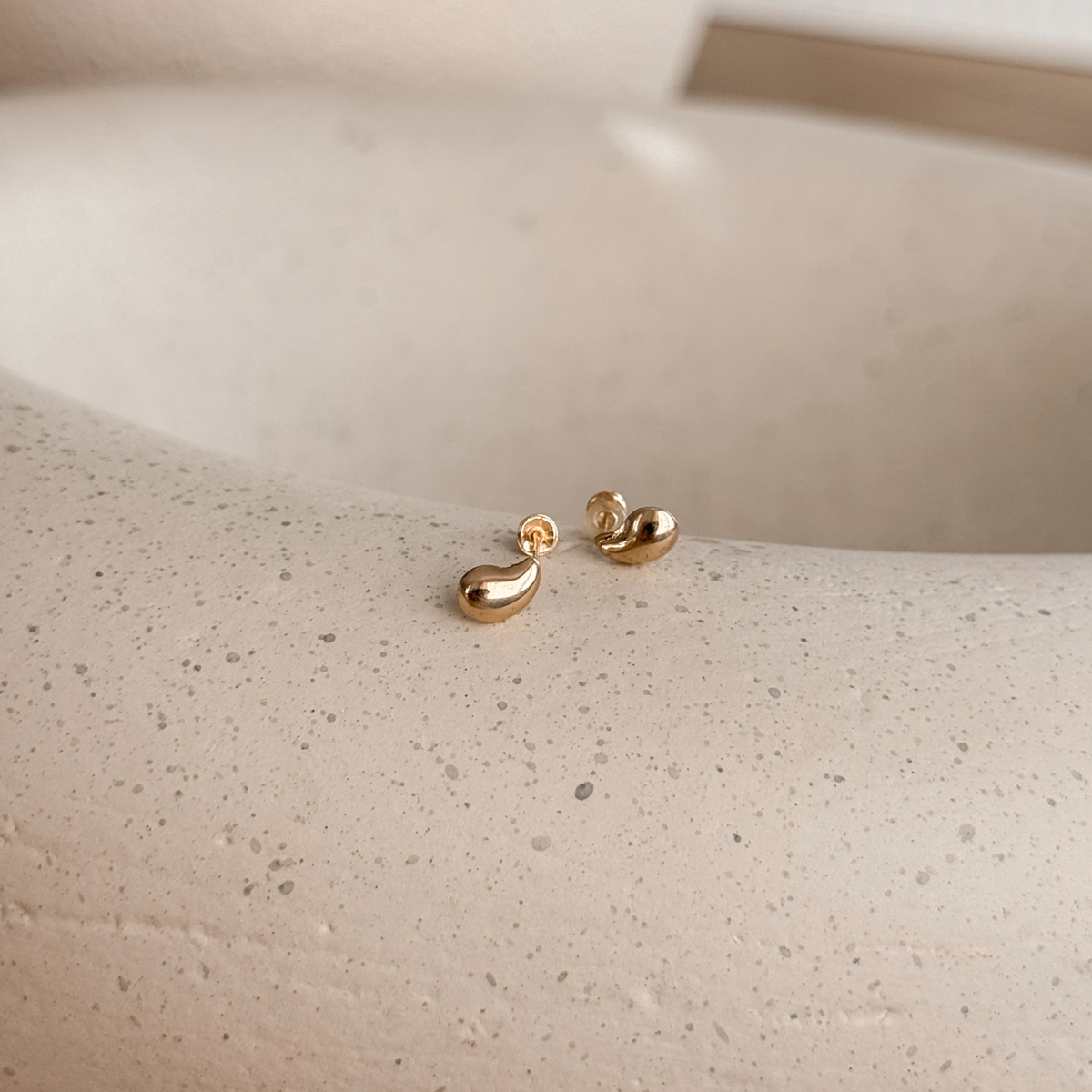 10K solid gold water drop stud earrings with screw backs on a speckled stone dish – Liv Aura