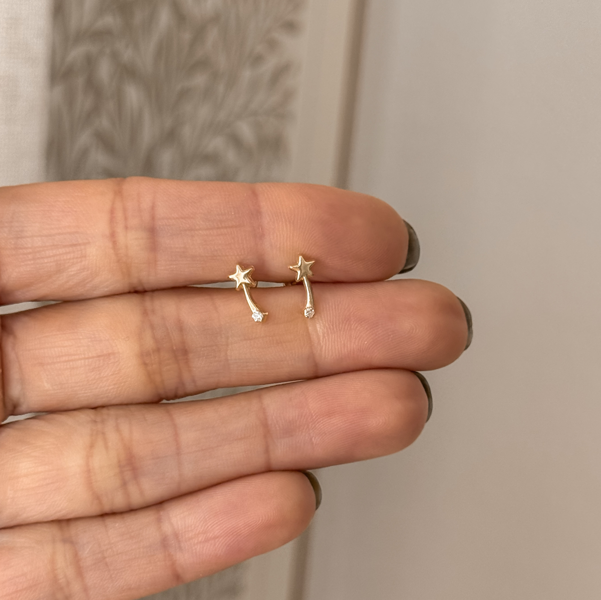 10K solid gold comet stud earrings held in hand to show the size – Liv Aura