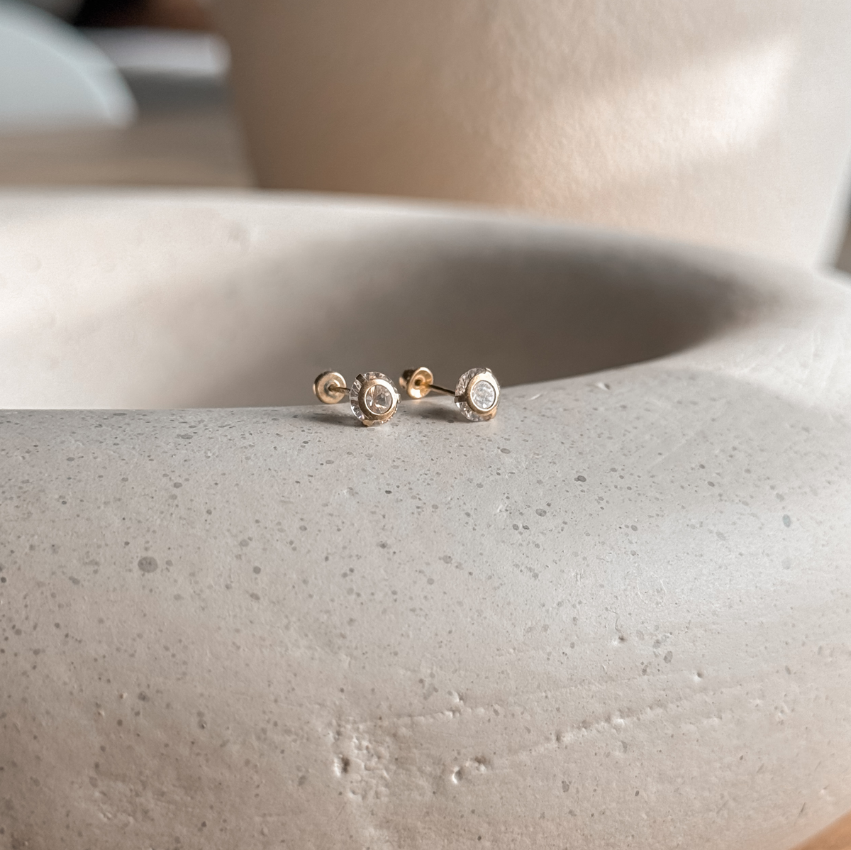 10K solid gold 5mm round CZ stud earrings on a speckled stone dish – Liv Aura
