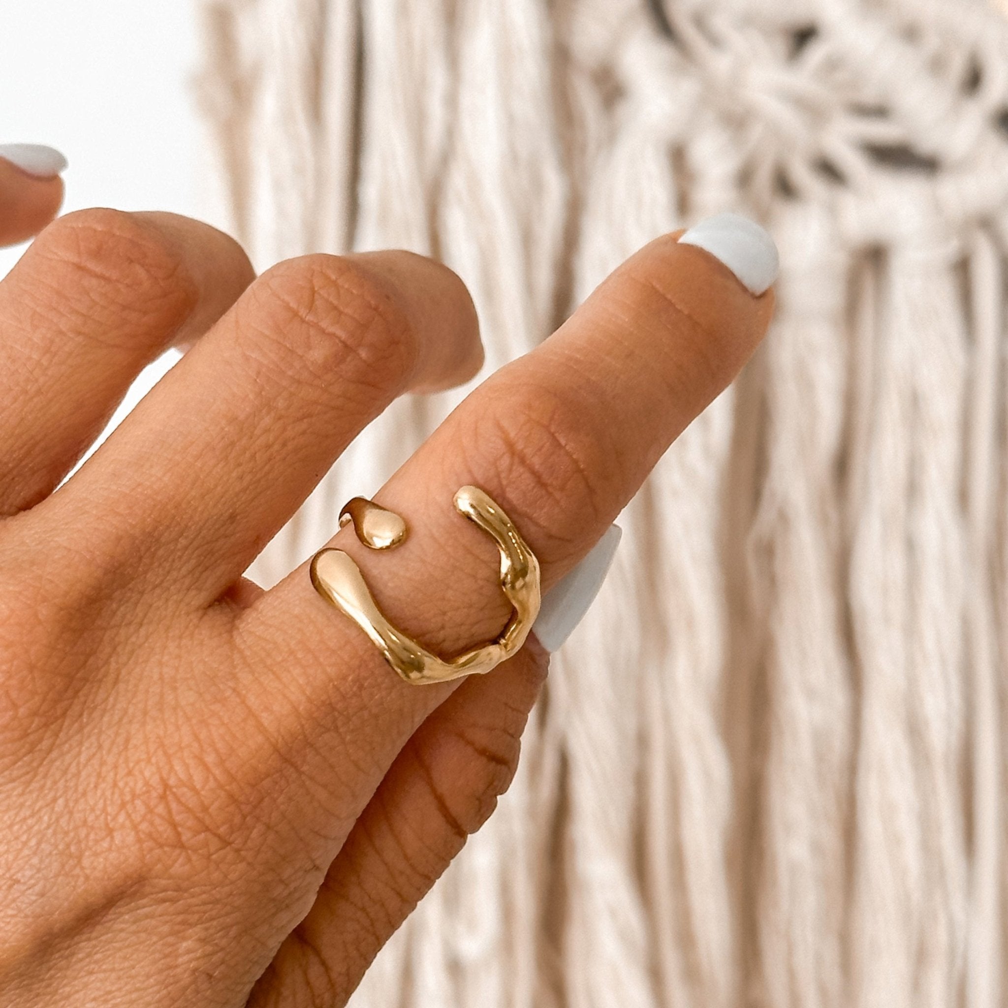 Abstract irregular gold ring worn on hand