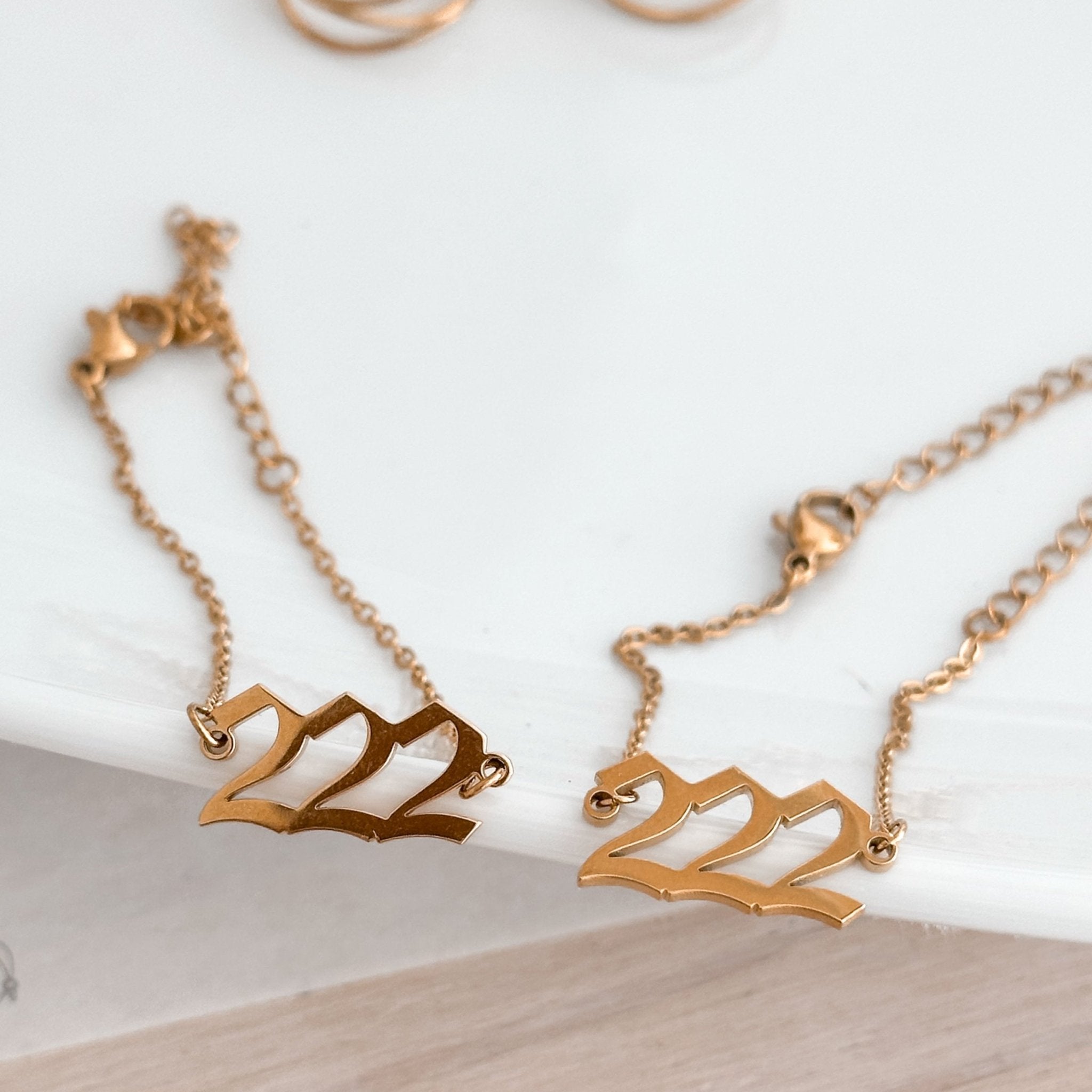  gold 222 bracelet displayed on white ceramic plate
