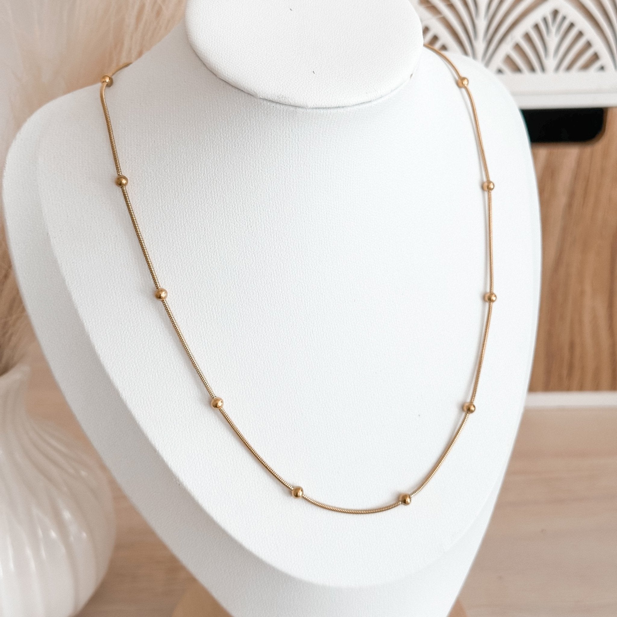 Single snake beaded necklace shown on white jewelry display – dainty 18K gold-plated everyday necklace
