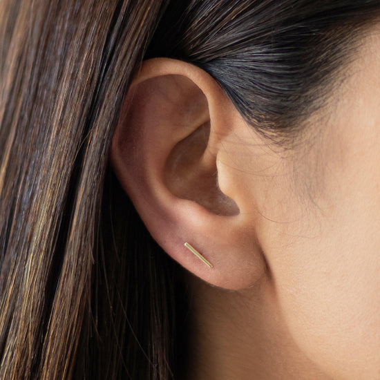 Load image into Gallery viewer, 10k gold Gold-toned stud earrings with a simple straight bar design.Our long, minimalist bar earrings are the perfect everyday wardrobe staple. Dainty, lightweight, and perfectly comfortable... you&amp;#39;ll never want to take these beauties off

