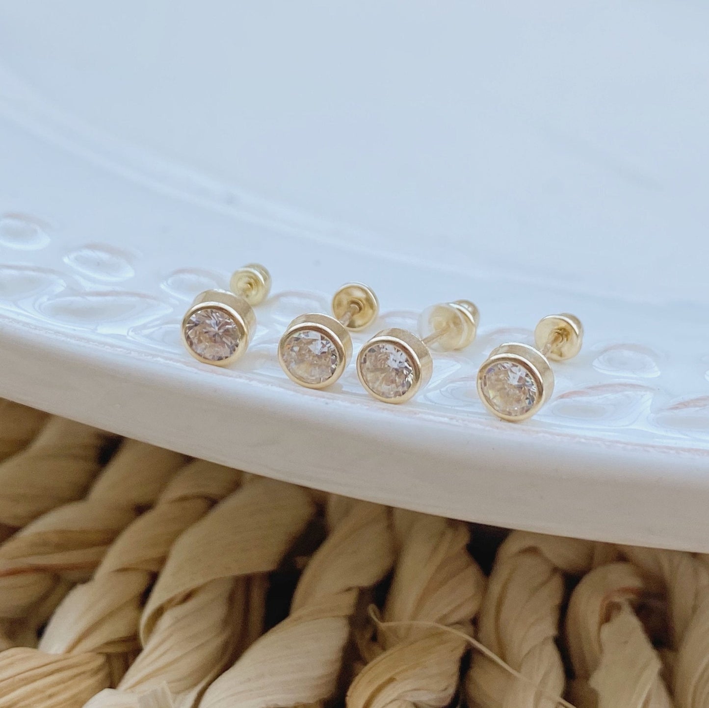 Load image into Gallery viewer, This 14k gold bezel earrings are simple, stylish, and minimalist. The screw back is to ensure they stay in place. These tiny dainty gold studs are perfect for everyday wear.
