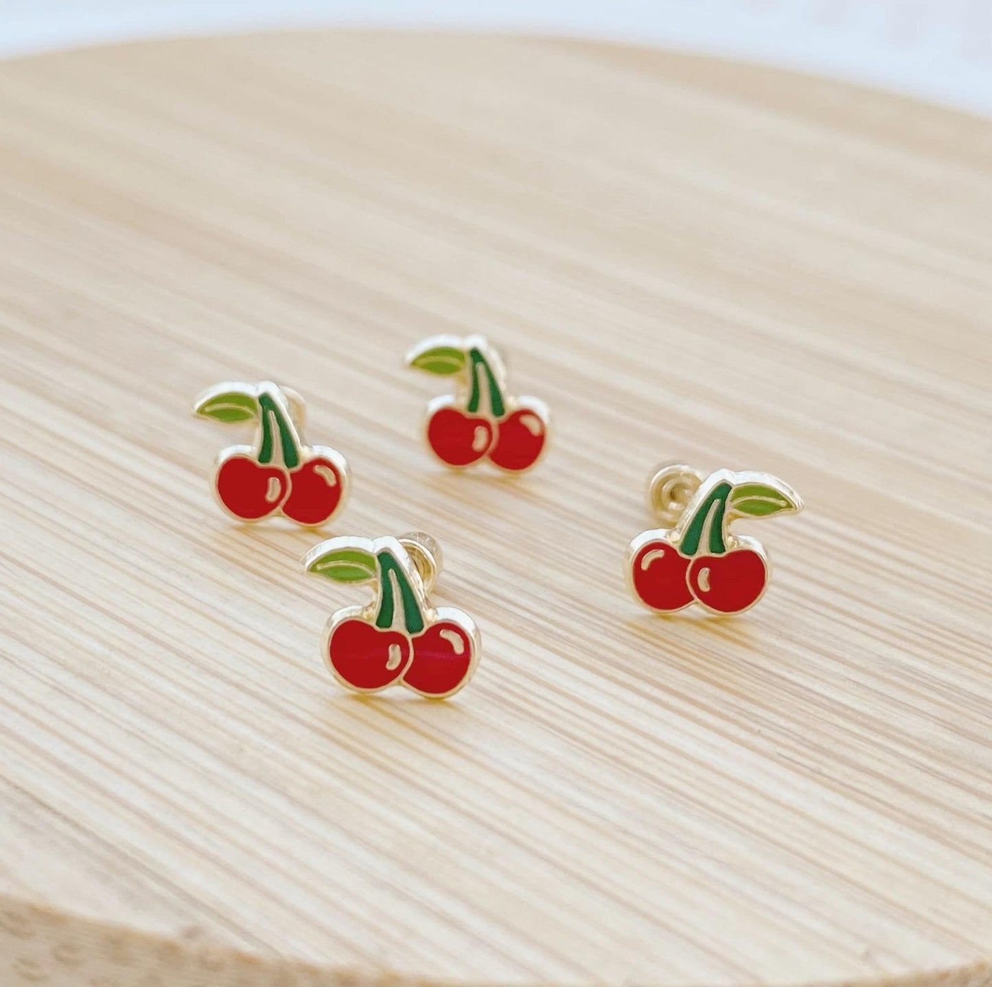 If you love cherries, you'll absolutely fall for these Dainty Cherry Stud Earrings! Our cherry earrings are handmade from authentic 10k gold, with each and every one of the tiny red gems being seen to do them justice. The screws backed backs give you a snug and secure fit, so these are perfect to sleep in or wear while lounging around the house.