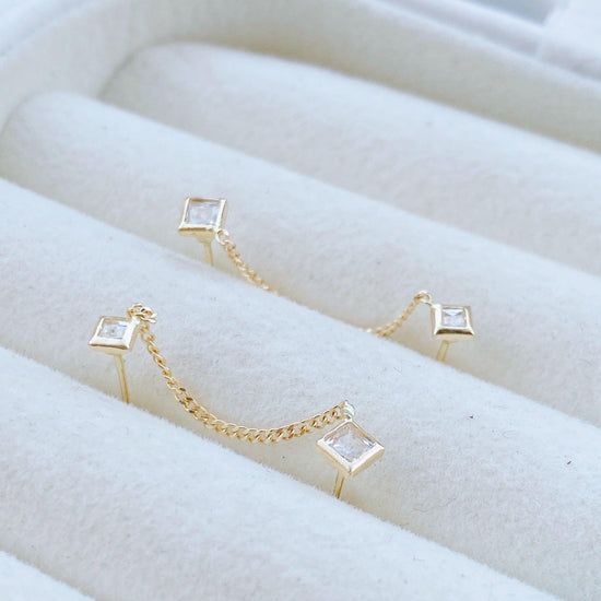 Make a second hole in your ear, without any pain and have fun with our double square chain earring stud connected with this elegant gold chain. It’s made of high quality 10K gold,