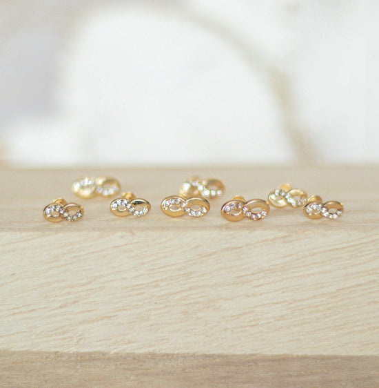 Load image into Gallery viewer, Our Infinity Studs are the perfect everyday earrings. They feature a 10K gold infinity symbol inlaid on each stud, and are made of high quality sterling silver. These beautiful earrings are great for any occasion, including weddings, bridal showers and more!
