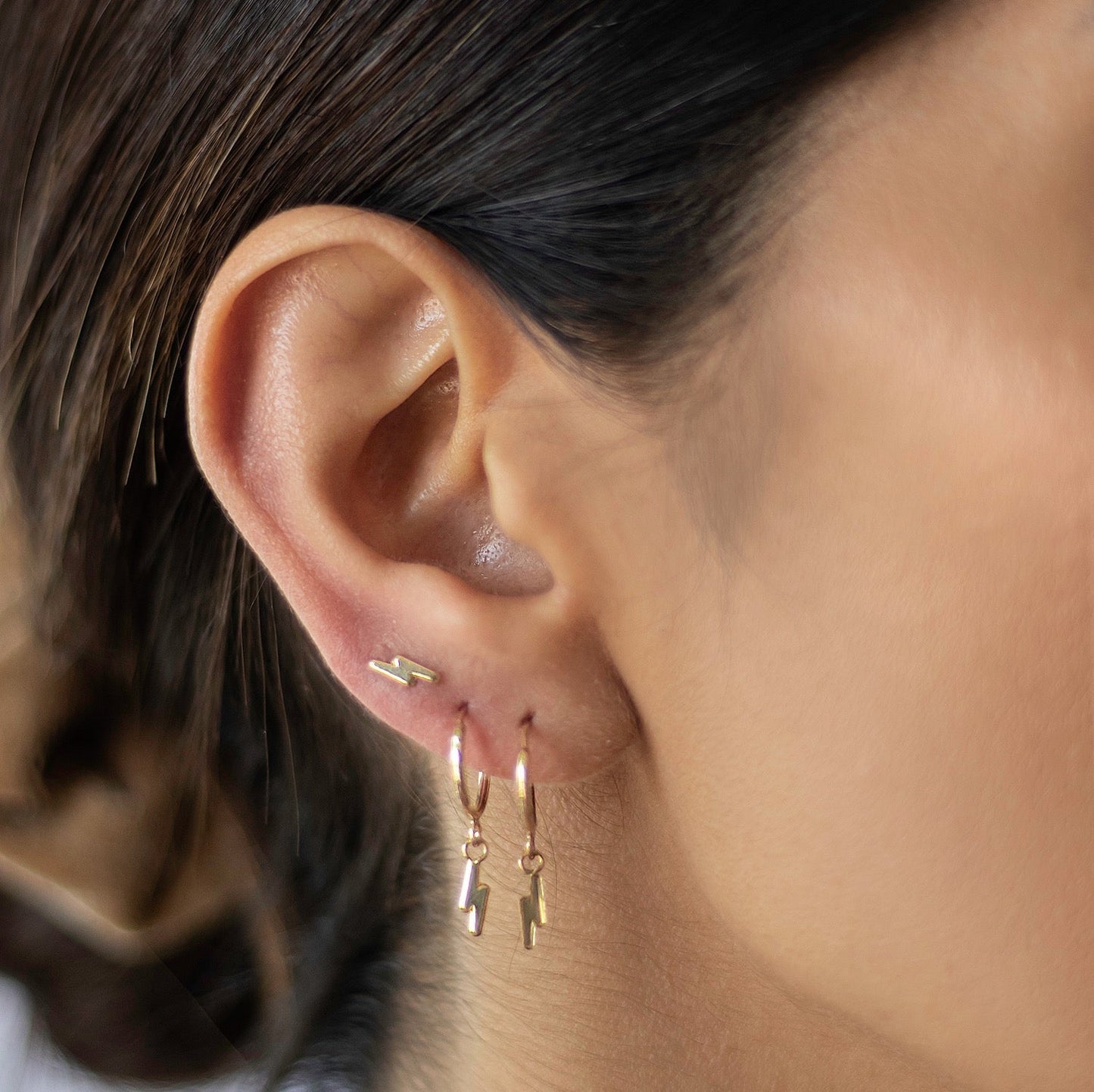 These tiny hoop earrings feature a lightening bolt design on the front and are 10k gold plated. The lightweight hoops make them perfect for wearing with studs or other small earrings so you can stack up the sparkle!