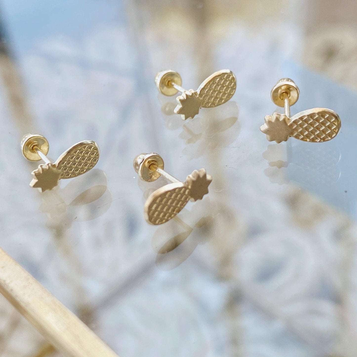 Load image into Gallery viewer, Our Pineapple Fruit Earrings are made with 10K gold and are a dainty and minimal pair of earrings that are perfect for everyday wear. Inspired by the tropical pineapple fruit, our pineapple studs have a screw back earring post so they fit more snugly in your ears.
