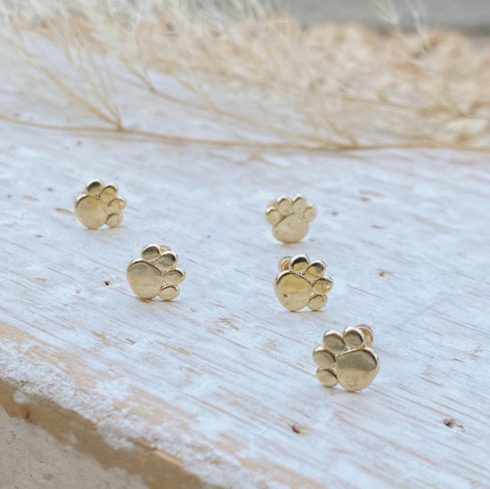 Load image into Gallery viewer, These cute little earrings feature an adorable paw print on one side of the stud, and will make a beautiful addition to any jewelry collection! You can choose from a variety of different color options for our gold-plated dog lover jewelry.
