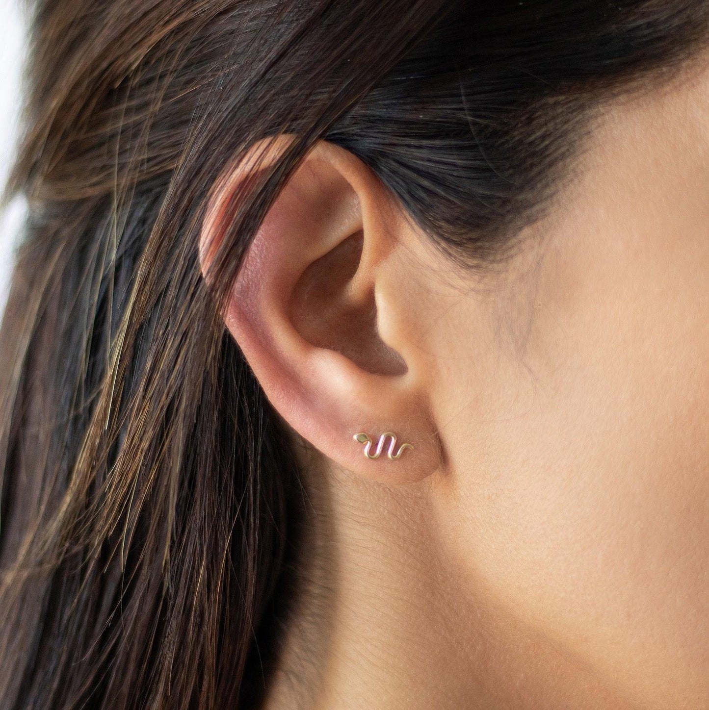 These gold snake earrings will be your go-to minimalist piece. These gold serpents are the perfect length for a second hole and look beautiful on their own or stacked with our other stud earrings.