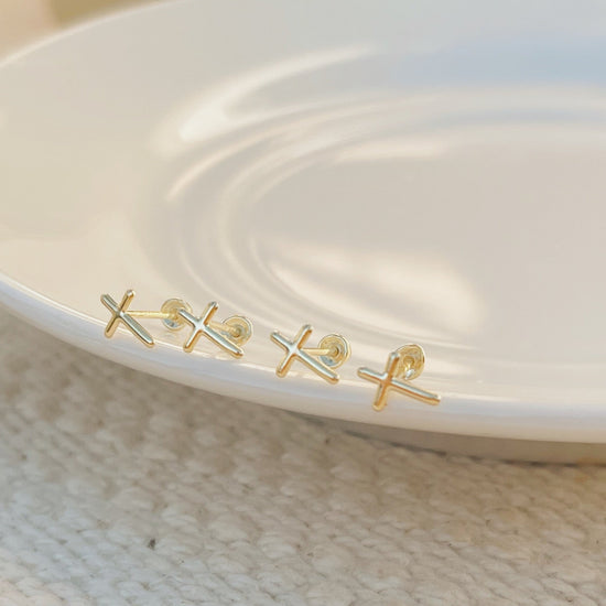 Close-up of 10K gold cross stud earring, screw back, hypoallergenic and lightweight